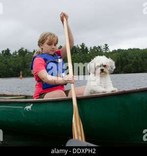 Mädchen in einem Kanu mit ihrem Zuchon Welpen, Lake Of The Woods, Keewatin, Ontario, Kanada Stockfoto