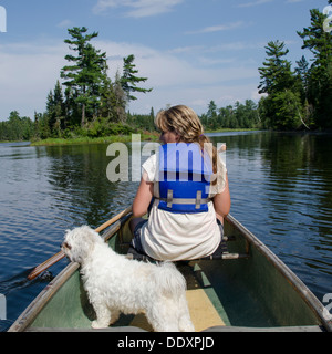 Mädchen in einem Kanu mit ihrem Zuchon Hund in eine Lake, Lake Of The Woods, Keewatin, Ontario, Kanada Stockfoto