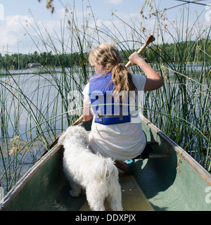 Mädchen in einem Kanu mit ihrem Zuchon Hund in eine Lake, Lake Of The Woods, Keewatin, Ontario, Kanada Stockfoto