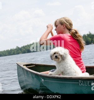 Mädchen in einem Kanu mit ihrem Zuchon Hund auf eine Lake, Lake Of The Woods, Keewatin, Ontario, Kanada Stockfoto