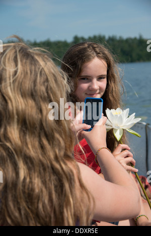 Mädchen, die ein Bild von ihrem Freund, Lake Of The Woods, Keewatin, Ontario, Kanada Stockfoto