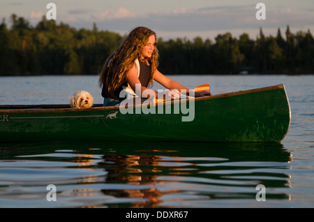 Mädchen und ihr Zuchon Welpe in einem Kanu, Lake Of The Woods, Keewatin, Ontario, Kanada Stockfoto