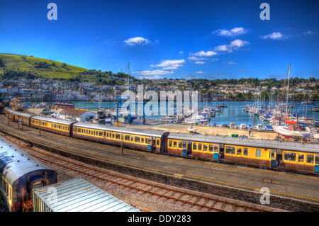 Dartmouth Bahnhof Devon England trainieren mit gelben Wagen und Boote im Hintergrund mit blauer Himmel in HDR Stockfoto