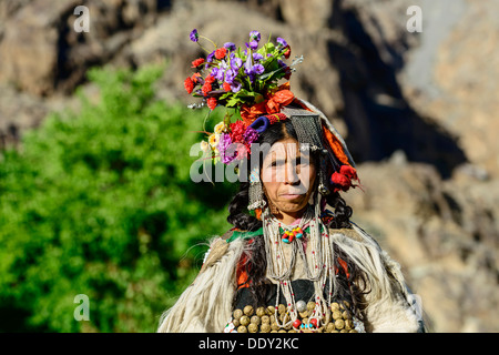 Frau des Stammes Brokpa tragen traditionelle Kleid mit Blumen Kopfbedeckung Stockfoto