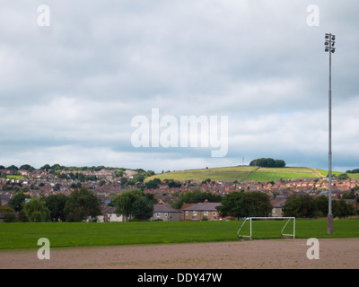 Öffentliche Fußballplätze mit Torpfosten und Flutlicht, umrahmt von grünen Hügeln und launisch bewölktem Himmel in Belper, Derbyshire Stockfoto