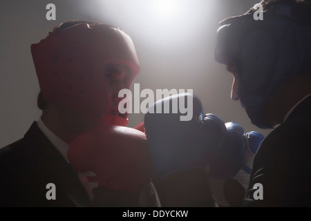 Geschäftsleute mit Boxhandschuhen einander zugewandt Stockfoto