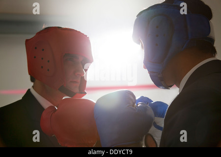 Geschäftsleute mit Boxhandschuhen einander zugewandt Stockfoto