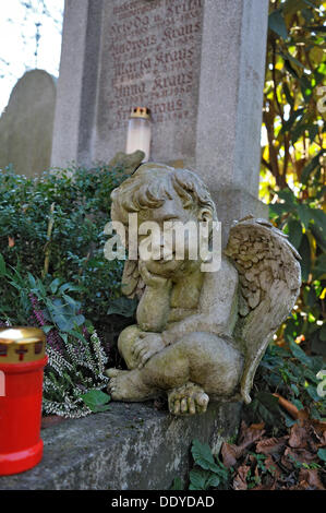 Putte und votive Kerze mit Herbst Blätter auf dem Ostfriedhof oder Osten Friedhof, München, Bayern Stockfoto