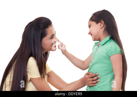 Niedliche kleine Mädchen berühren Mutters Nase über weißem Hintergrund Stockfoto