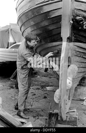 Ein Mann Reinigung der Kiel von seinem Boot, Schweden, 1966. Artist: Unbekannt Stockfoto