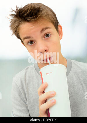 Porträt, junge, Jugendliche trinken aus einer Tasse mit einem Strohhalm Stockfoto