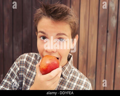 Porträt, junge, Jugendlicher, die einen Apfel beißen Stockfoto