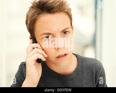 Porträt, junge, Teenager auf der Suche wütend während des Gesprächs auf dem Handy Stockfoto