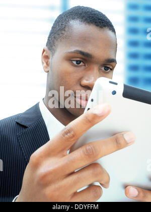 Junger Geschäftsmann, Afro-Amerikaner, amerikanisch, respektabel, konzentriert, Blick auf seinem iPad Stockfoto