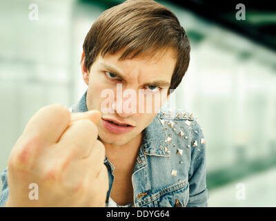 Aggressive junge Mann trägt eine beschlagene Jeansjacke, Porträt Stockfoto