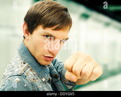 Aggressive junge Mann trägt eine beschlagene Jeansjacke, Porträt Stockfoto