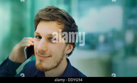 Porträt eines jungen Mannes mit einem Bart, ein Telefongespräch, lächelnd, entspannt Stockfoto