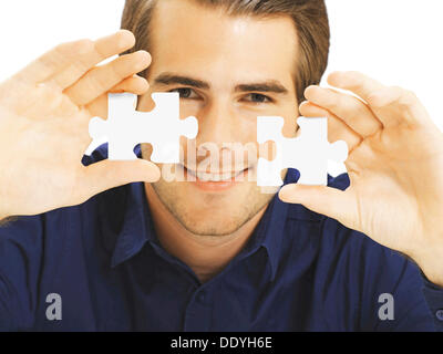 Geschäftsmann hält Puzzleteile Stockfoto