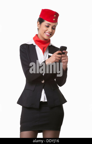 Glückliche junge Stewardess messaging auf Handy isoliert auf weißem Hintergrund Stockfoto