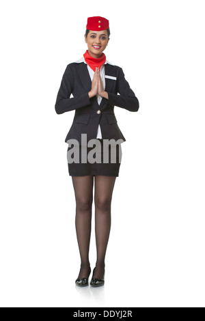 In voller Länge Portrait von junge Stewardess Gruß Namaste isoliert auf weißem Hintergrund Stockfoto