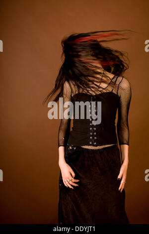 Frau, gekleidet in einem gotischen Stil stehen und wirft ihr Haar Stockfoto