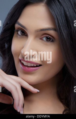 Porträt von eine süße junge Frau lächelnd über farbigen Hintergrund Stockfoto