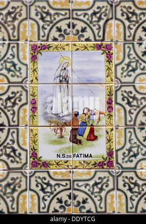 Bemalte Zinn - Glasierte keramische Azulejos Fliesen mit der Darstellung der Figur der Gottesmutter von Fatima formal als Die Muttergottes vom heiligen Rosenkranz von Fatima, eine Römisch-katholische Titel der Allerseligsten Jungfrau Maria Dekoration Fassade eines Wohnhauses in der Stadt Olhão, Algarve, die südlichste Region Portugals bekannt Stockfoto