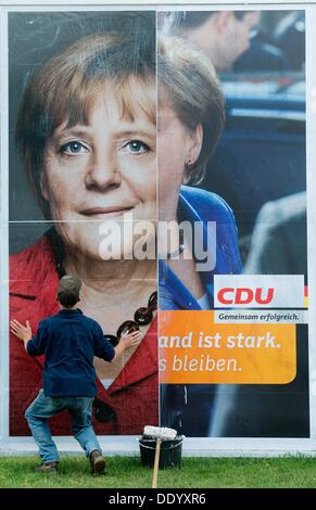 Hannover, Deutschland. 09. September 2013. Eine Person legt einen neuen Wahlplakat für die bevorstehende Bundestagswahl von der christdemokratischen Partei mit einem Bild von Bundeskanzlerin Angela Merkel auf einer vorherigen Wahlplakat in Hannover, Deutschland, 9. September 2013. Foto Julian Stratenschulte Credit: Dpa/Alamy Live-Nachrichten Stockfoto