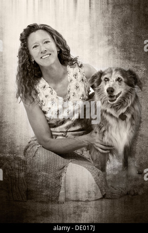 Schwarzen & weißen Studio Foto von attraktiven Frau im Sommerkleid mit ihrem Haustier Hund, Miss Kitty, ein Australian Shepherd-mix Stockfoto