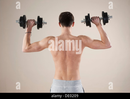 Junger Mann tun Krafttraining mit Hanteln Stockfoto