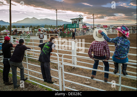 Junge & Mädchen gehockt Corral Zaun beobachten das Chaffee County Rodeo, Poncha Springs, Colorado, USA Stockfoto