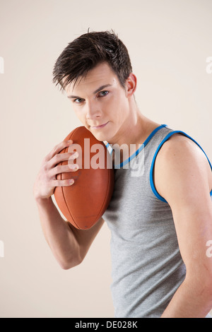 Junger Mann mit einem Fußball in der hand Stockfoto