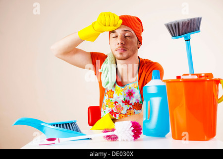 Junger Mann sucht danach erschöpft die Reinigung Stockfoto