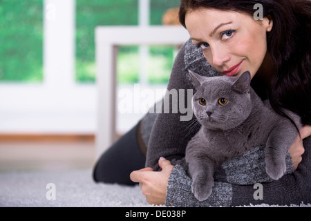 Eine junge Frau zu Hause mit einer Britisch Kurzhaar-Katze Stockfoto