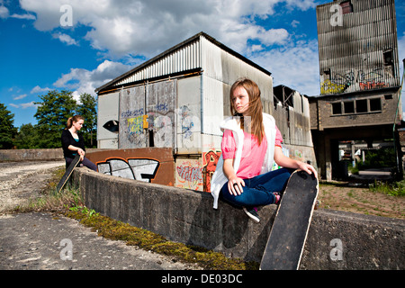 Mädchen im Teenageralter mit Skateboard in einer städtischen Umgebung Stockfoto