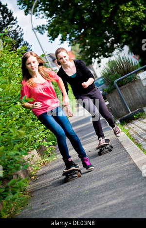 Zwei Mädchen im Teenageralter Skateboarden auf einem Pflaster Stockfoto