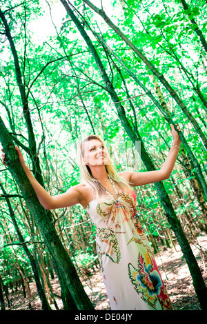 Junge Frau trägt ein Sommerkleid im Wald Stockfoto