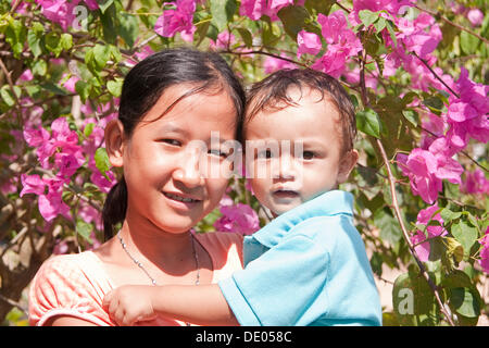 Junges Mädchen mit einem kleinen Kind in ihren Armen, Phu Quoc, Vietnam, Asien Stockfoto