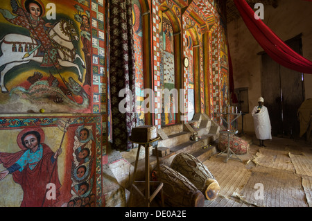 Priester ein Kreuz haltend. und Wandgemälde von St George töten den Drachen, Narga Selassie Kirche Dek Insel, Tana-See, Bahir Dar, Äthiopien Stockfoto