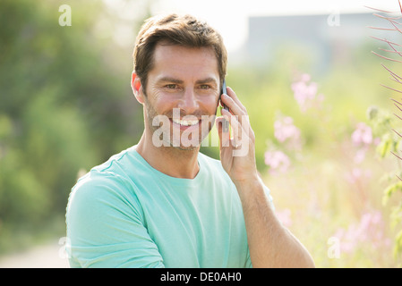 Reifer Mann mit Handy und genießen Sie die Natur Stockfoto