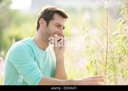 Reifer Mann mit Handy und genießen Sie die Natur Stockfoto