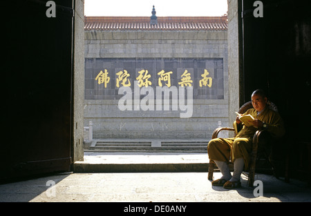 Ein Mönch liest ein Buch im Zhusheng Si Tempel, einem buddhistischen Kloster aus dem 8. Jahrhundert, das sich am Fuße des Berges Heng und im Norden der antiken Stadt Mount Heng im Hengshan Bezirk Hunan, China, befindet Stockfoto