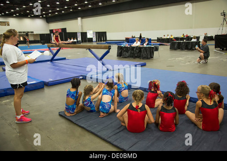 Detroit, Michigan - Mädchen warten ihrerseits auf dem Schwebebalken während der Olympischen Spiele in AAU Junior konkurrieren. Stockfoto