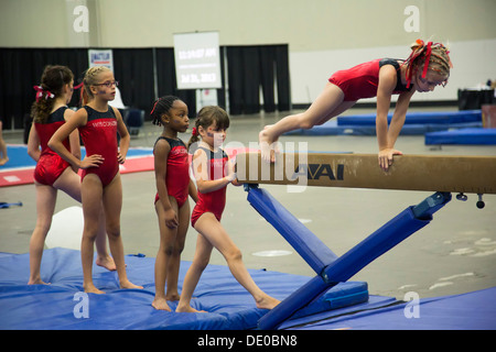 Detroit, Michigan - Girls Aufwärmen vor dem Wettkampf auf dem Schwebebalken während der AAU Junior Olympischen Spiele. Stockfoto