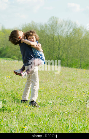 Junge Geschwister umarmen im freien Stockfoto