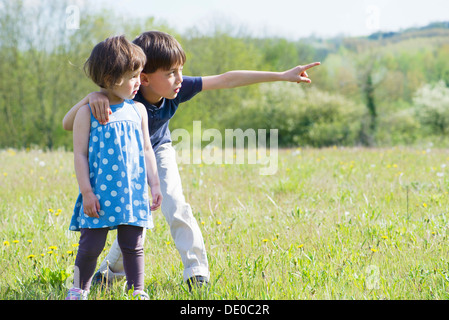 Kinder stehen im Feld zusammen, etwas in der Ferne betrachten Stockfoto