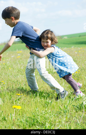 Junge Geschwister zusammen spielen im freien Stockfoto