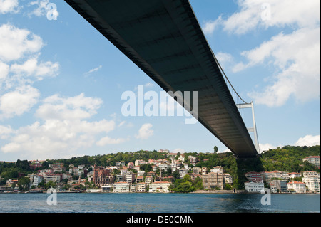 Großen Aussetzung Straßenbrücke über einen Fluss vor einem blauen Himmelshintergrund mit Residenzen unter Stockfoto