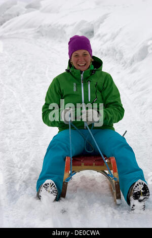 Schlitten-Fahrer fahren hinunter ins Tal, Zillertal, Österreich Stockfoto