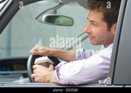 Mann fahren Autos mit Tasse Kaffee in der hand Stockfoto